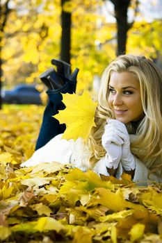 Lady lying on the ground of maple leaves