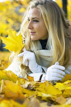 Lady lying on the ground of maple leaves