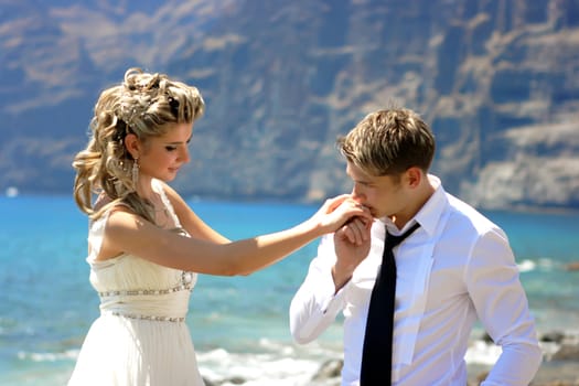 Bridegroom kissing a hand of a bride