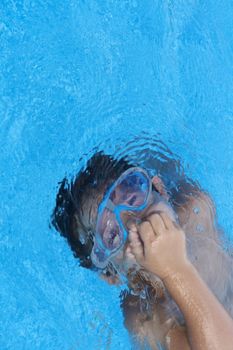 a young boy in pool with goggles on