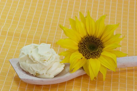 Vegetable oleomargarine on a cooking spoon and sunflower