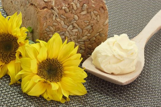 Bread and oleo on a cooking spoon with sunflowers