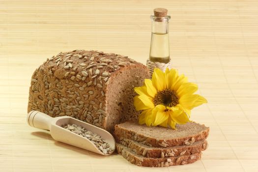 Sunflower seeds, sunflower-seed bread and sunflower oil with sunflower blossom