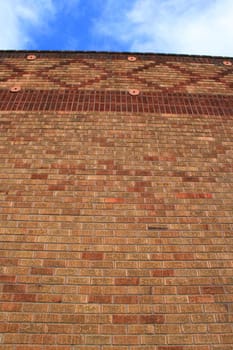 Brickwall over blue sky showing unique pattern.
