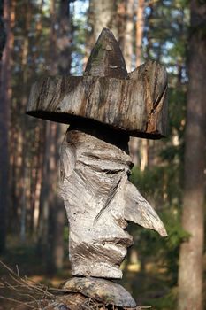 Weathered handmade wooden sculpture in the middle of wilderness