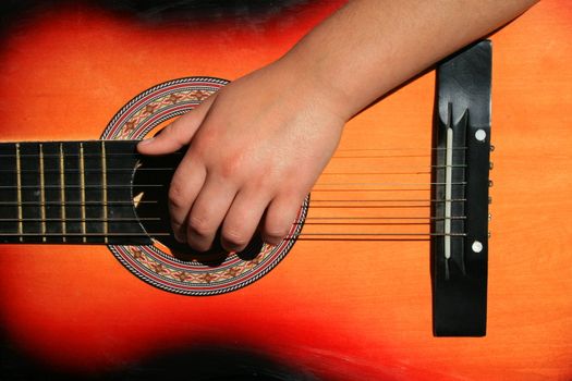 Close up of a person playing guitar.
