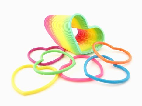 A group of colorful hearts and a heart shaped slinky isolated on a white background