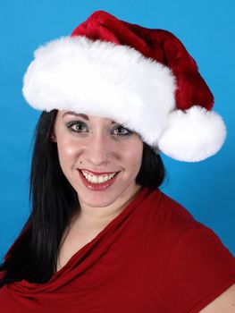 A pretty young pierced adult woman in a Santa hat cheerfully smiles.