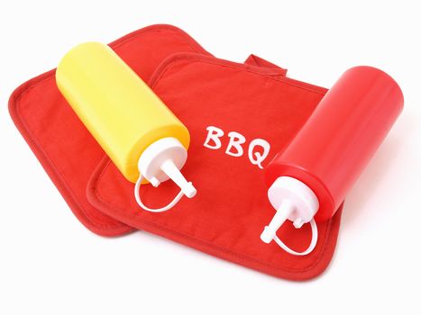 Ketchup and Mustard squeeze bottles laying on two red potholders.