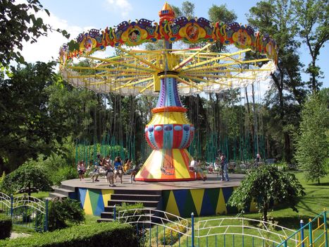 Children go for a drive on a roundabout in park