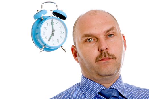 Businessman looking slightly annoyed with a clock next to his head
