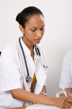 Attractive female doctor writing something down in her medical files