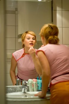blonde woman with pink top at the mirror