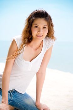 young asian woman sitting at the beach happily rest and relax in casual jeans wear