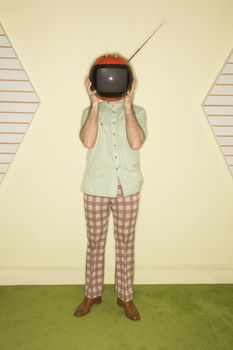 Caucasian mid-adult man wearing vintage clothing holding round red retro television in place of head.