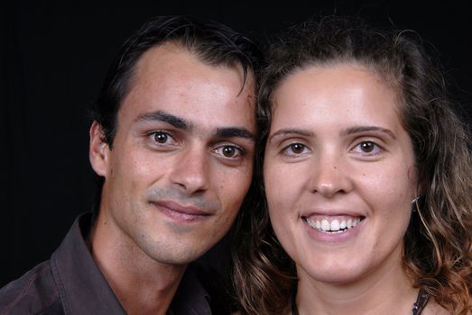 young couple together portrait on black background