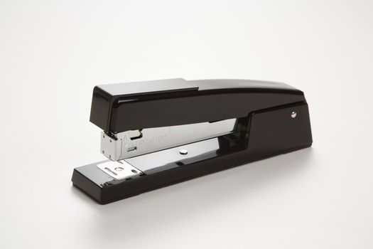 Black stapler on white background.