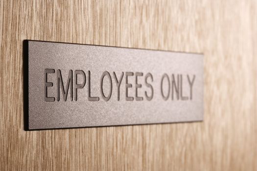 Employees only sign on wooden door.