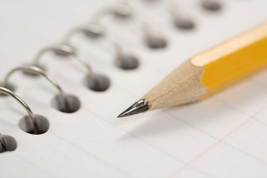 Close up of pencil on top of spiral bound notebook.