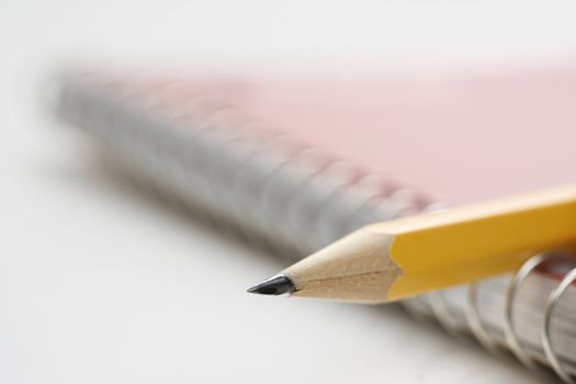 Close up of pencil on top of spiral bound notebook.