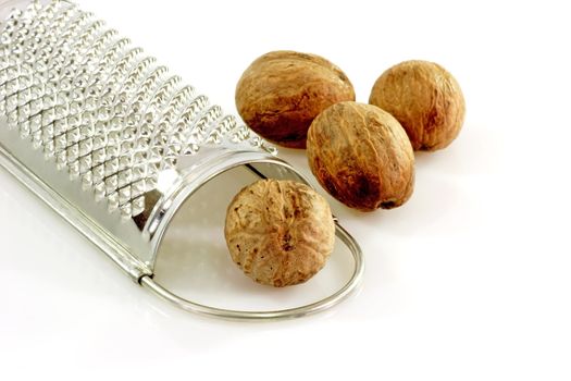 Close up of four nutmegs with a grater
