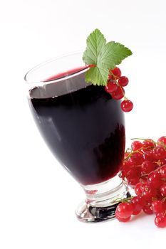 A glass of black currant juice with garnish on light background