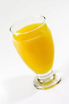 Glass of orange juice on light background