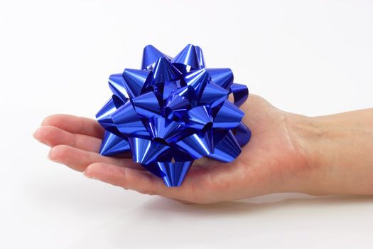 Close up of a blue bow in a hand on light background