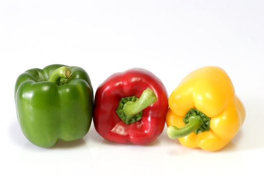 Yellow, red and green paprika on light background