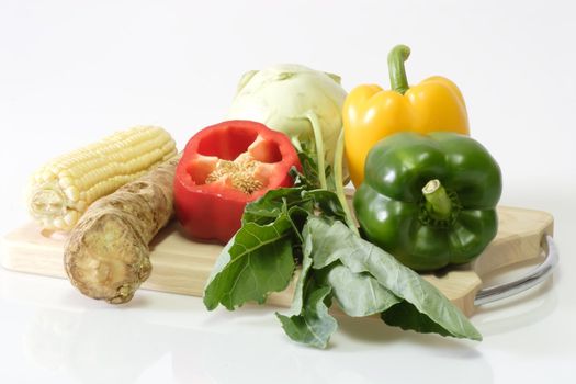Various vegetables on a cutting board on light background