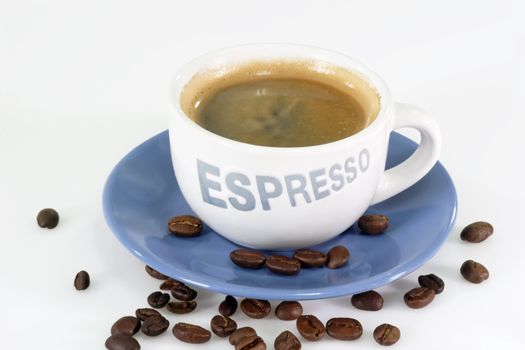 Expresso coffee  over roasted coffee beans.
