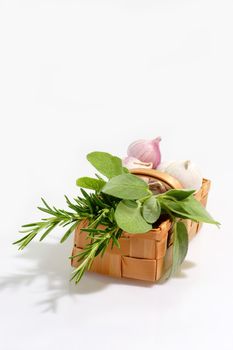 Basket of culinary herbs on light background