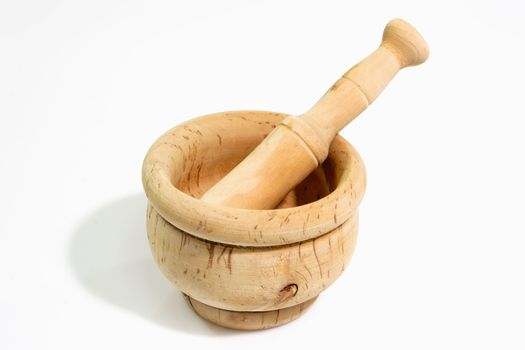 Wooden mortar with pestle on light background