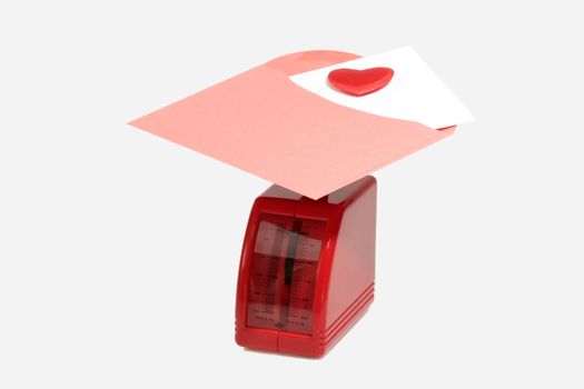 Red Letter scale with red Envelope and a velvet Heart on bright Background