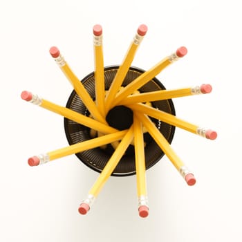 Top view of group of pencils in pencil holder arranged in a spiral shape.