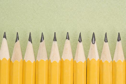 Sharp pencils arranged in an even row.