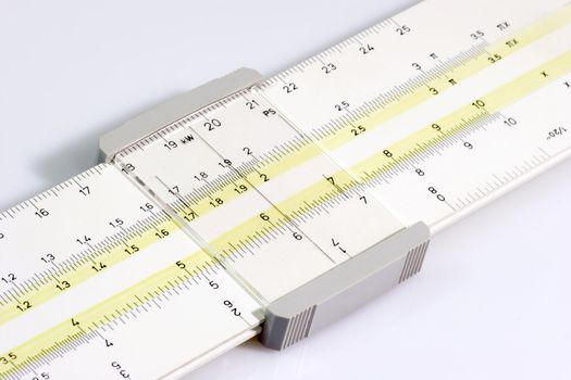 Close-up of an old Sliderule on white background
