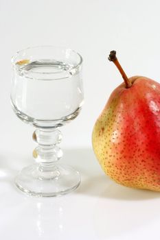 Glass of pear brandy on the bright background