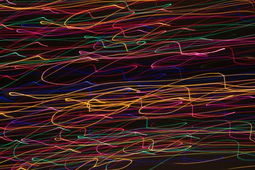 Multicolored lights forming abstract squiggle pattern from motion blur.