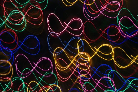 Multicolored lights forming abstract squiggle pattern from motion blur.