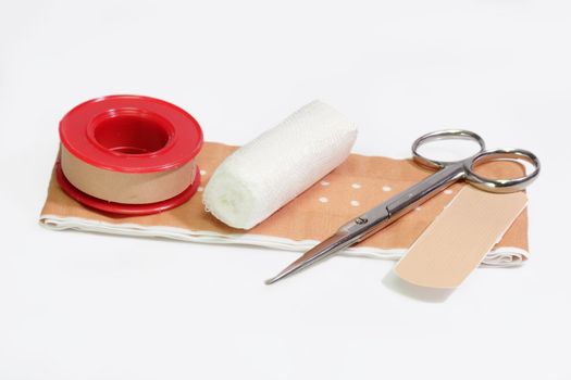 First aid kit and bandage on a bright background.
