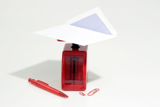 White envelope on a red letter scale on bright background
