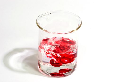 Graduated beaker with red fluid on bright background