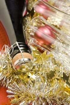 Three glasses with wine bottle and Christmas decoration on red background.