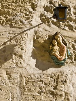 Madonna and baby Jesus icon on wall with lamp  