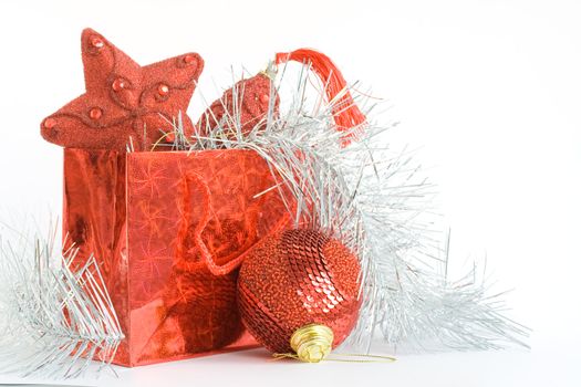 Red bag with christmas toys on white background. Focus on ball