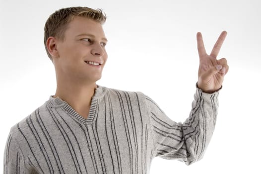 successful young man showing peace sign against white background