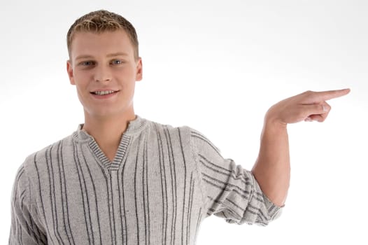 smiling man pointing to the side against white background