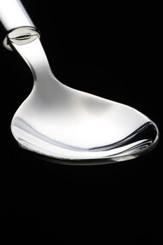 empty stainless steel spoon over black background
