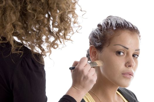 beautician doing make up of woman against white background